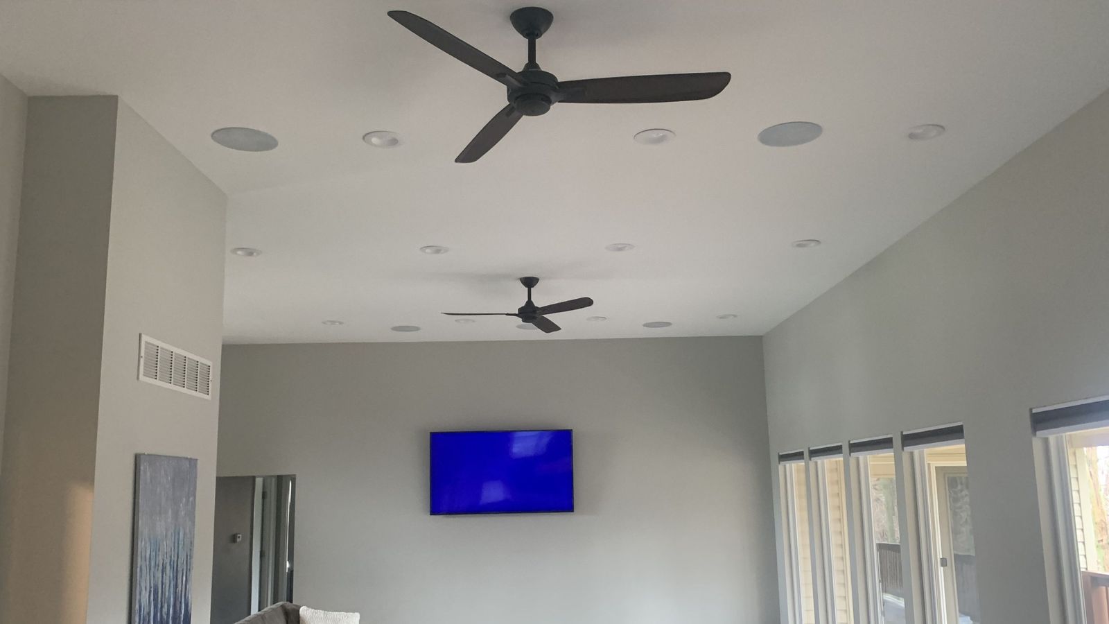 Living room with wall-mounted TV and in-ceiling speakers